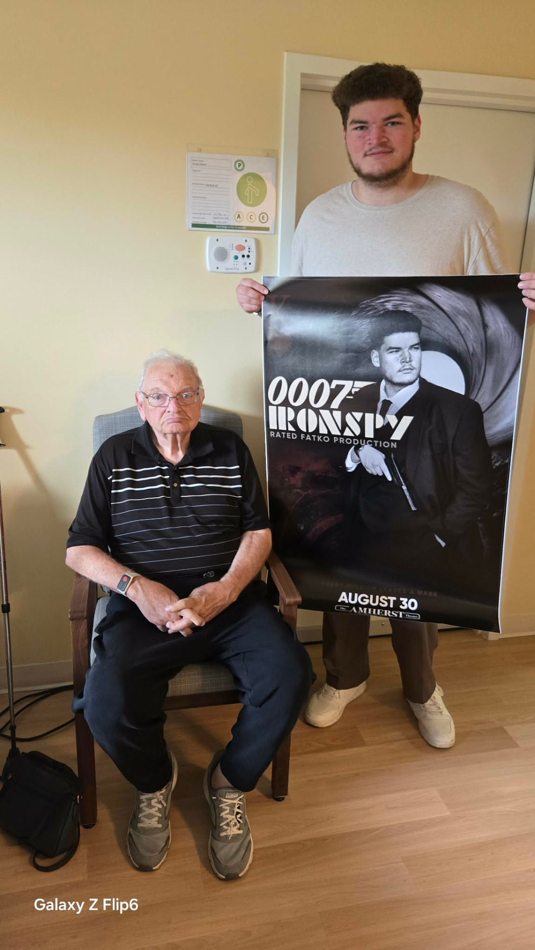 Two people posing with the 0007 Ironspy theatre poster