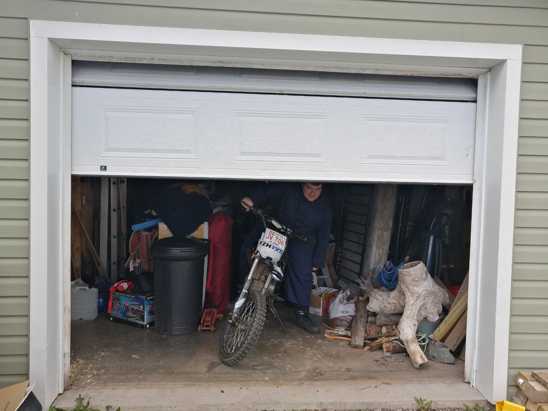 Performer moving a motorcycle from a garage for filming