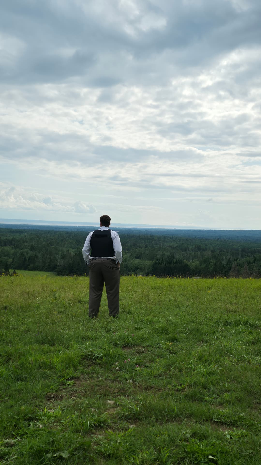 Actor overlooking a forest landscape while scouting a location