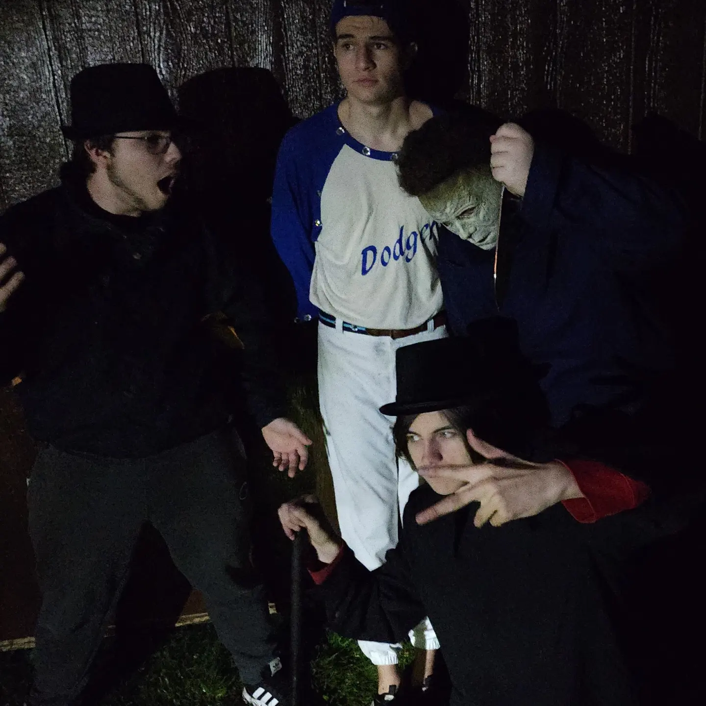 Cast members posing in Halloween and baseball costumes during a night shoot